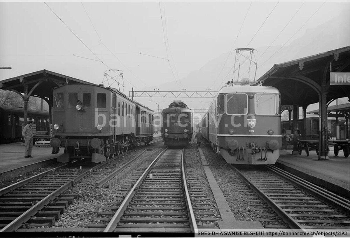 SGEG DH A SWN120 BLS-011: Die Lokomotiven Ce 6/6 121 der Bern-Neuenburg-Bahn (BN) mit Dienstzug, Ae 6/8 207 der Berner Alpenbahn-Gesellschaft Bern-Lötschberg-Simplon (BLS) und Re 4/4 II 11124 der Schweizerischen Bundesbahnen (SBB) mit Schnellzug in Interlaken Ost