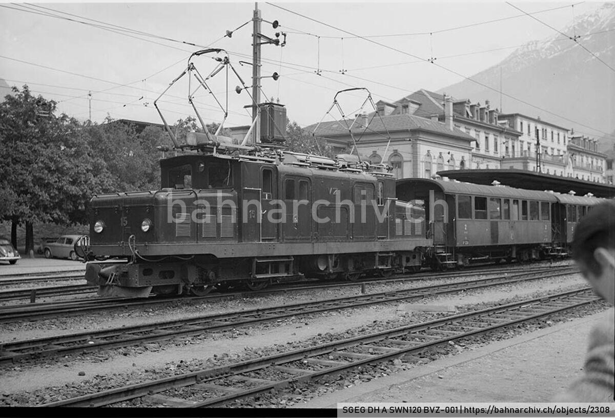 SGEG DH A SWN120 BVZ-001: Lokomotive HGe 4/4 15 der Compagnie du chemin de fer Brigue-Viège-Zermatt (BVZ) vor Reisezug in Brig
