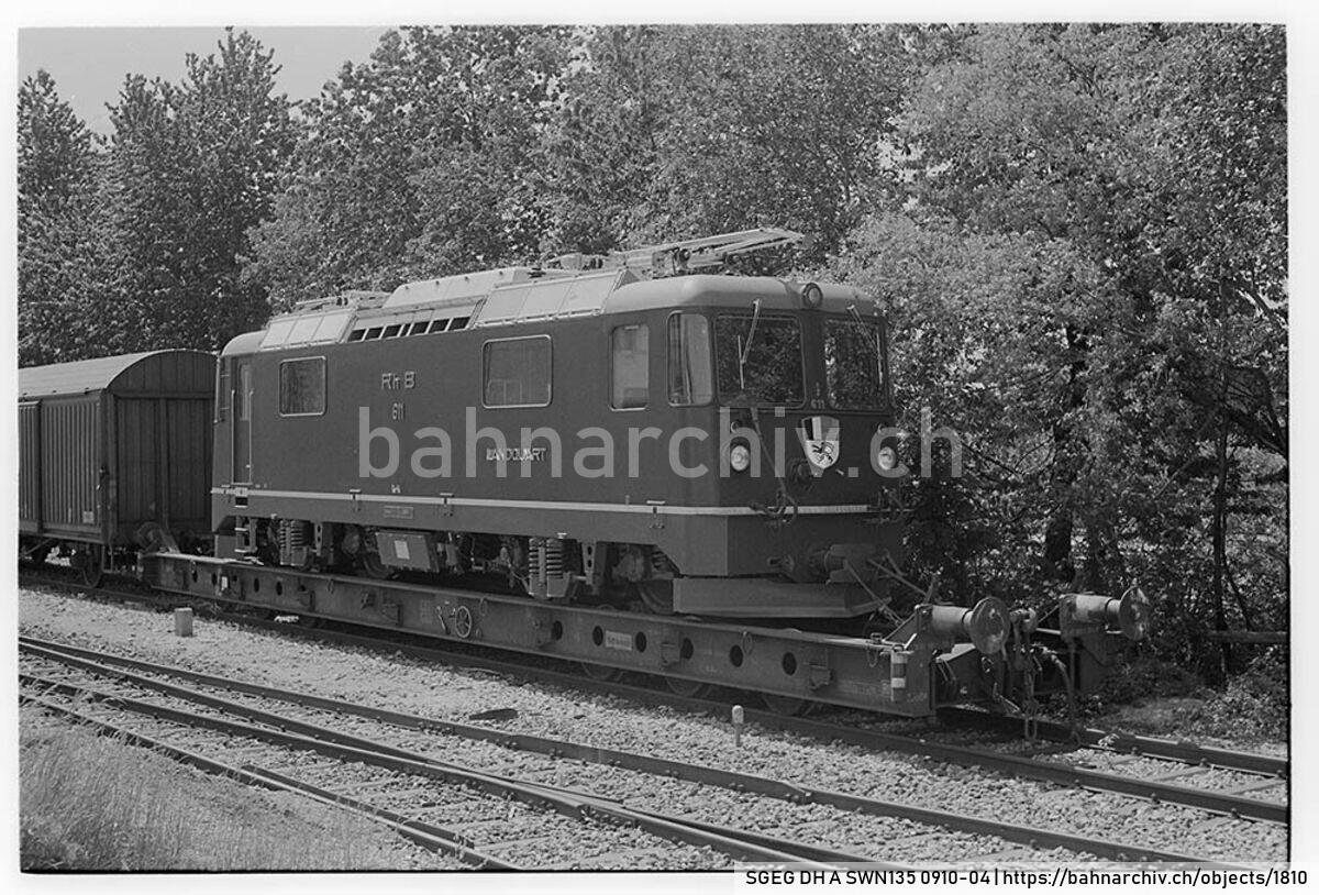 SGEG DH A SWN135 0910-04: Lokomotive Ge 4/4 II 611 der Rhätischen Bahn (RhB) auf Rollschemel Uaai 31 85 989 0 300-9 der Schweizerischen Bundesbahnen (SBB) in Igis