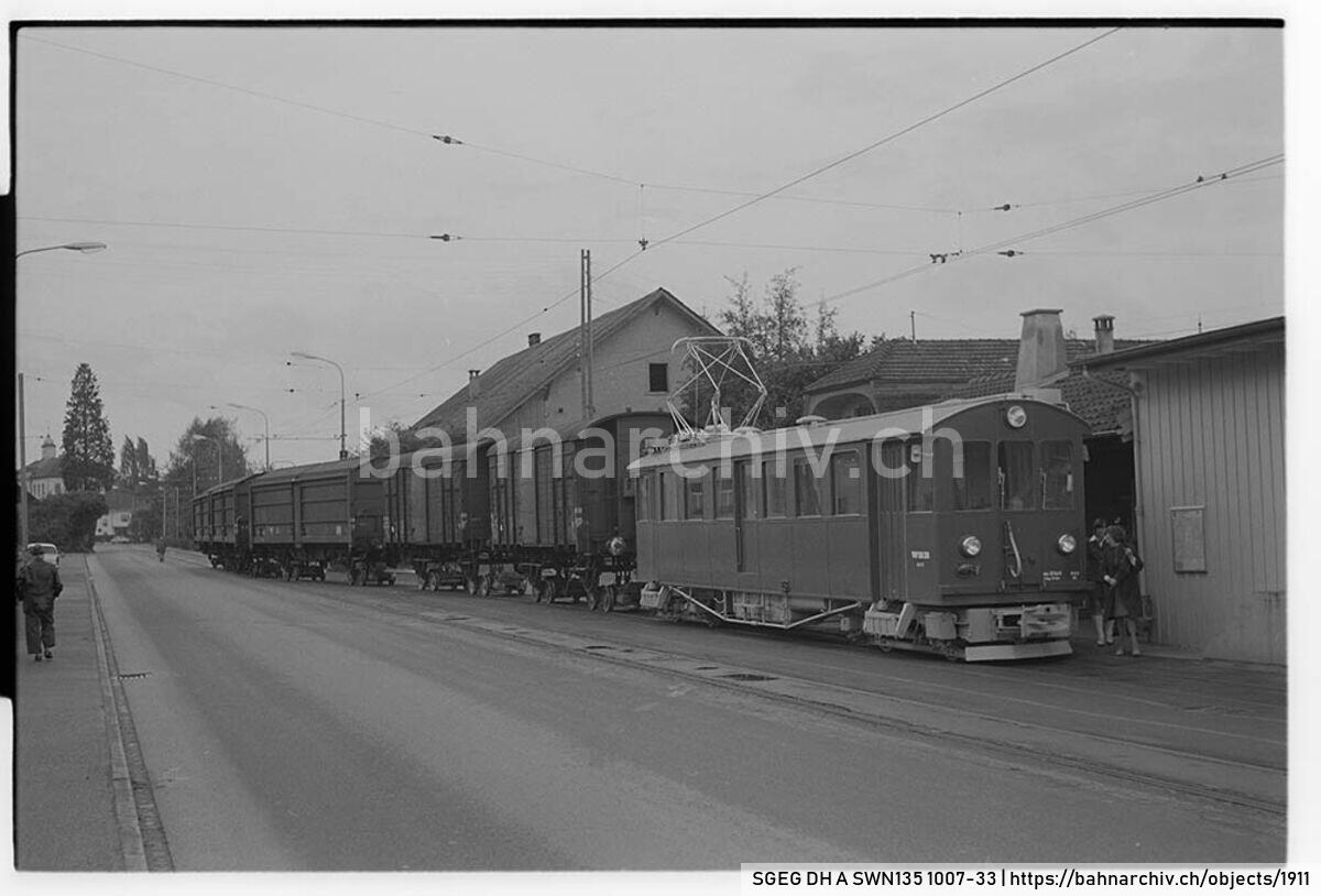 SGEG DH A SWN135 1007-33: Güterzug der Wynental- und Suhrentalbahn (WSB) mit Triebwagen De 4/4 17 und Güterwagen der Schweizerische Bundesbahnen (SBB) auf Rollböcken in Muhen